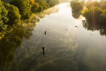 Poster Im Rahmen Luftaufnahme eines Mannes Fliegenfischen in einem Fluss während des Sommermorgens. © Lukas Gojda