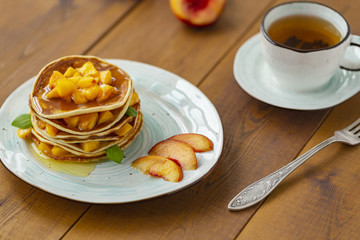 Pancakes with honey and fruit. Delicious breakfast.