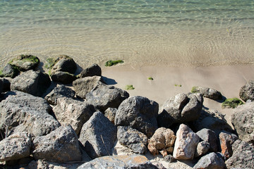 Fototapeta na wymiar Rocks and shallow sand in ocean water