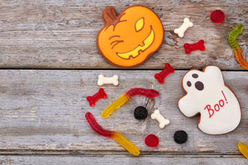 Halloween sweets on wooden background. Halloween cookies and jelly candies, copy space. Happy Halloween holiday.