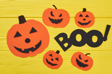 Halloween decorations background. Paper silhouette of different pumpkins on yellow background. Halloween holiday cutouts.