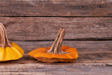Stem of orange pumpkin on wooden background. Piece of pumpkin on rustic wood. Preparation for Halloween.