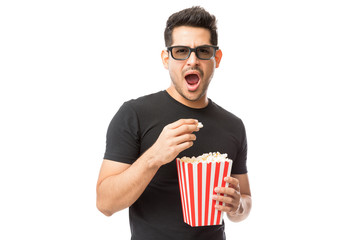 Fototapeta premium Scared Young Man Wearing 3D Glasses While Having Popcorn