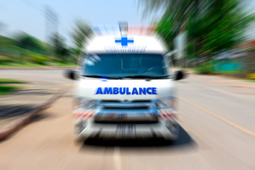 Looking from the rearview mirror Ambulance speeding to accident, Emergency ambulance travels through city street zoom effect applied for dramatic effect, Ambulance first aid abstract motion blur shot. © Amnat