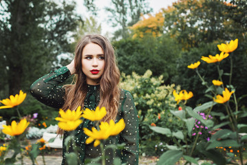 Beautiful young woman in flowers garden outdoors