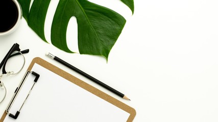 clipboard and white paper on white office desk background. Flat lay design.
