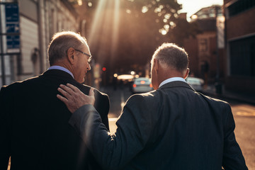 Senior businessman walking together outdoors