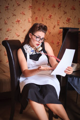 Beautiful woman with glasses talking on the phone with a document in her hands.