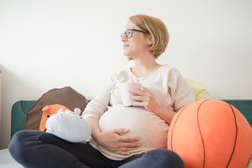 A pregnant woman caressing her belly 
