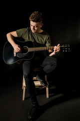 Guy in studio play on acoustic guitar