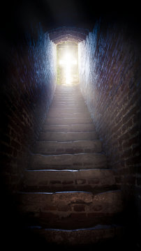 Light at end of tunnel in castle . Staircase leading to heaven or hell. Light cross of Christ . Walk to the cross .  Sunbeams and cross .  Jesus Christ . 