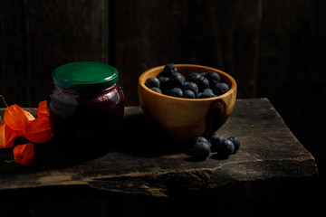 Homemade jam from plum and plum berries in a wooden bowl.