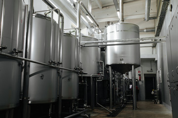 Modern brewery and equipment machinery tools for alcohol production. Steel vats or tanks and stainless pipes.