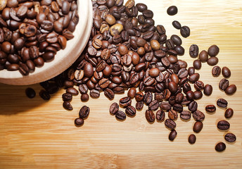 Coffee beans in a wooden cup. Coffee beans are scattered all over the city, close-up.