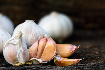 Garlic or Allium sativum L., white spices on brown woodden.