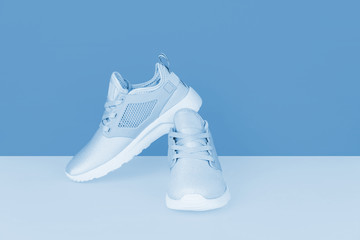 Shot of silver sneakers on blue background.