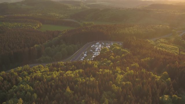 Nuerburgring overview Drone moving right car race arena german landscape trailerpark Eiffel forrest sunny clear sky