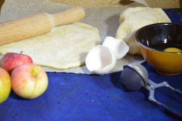 Various ingredients for winter seasonal baking and other recipes, honey, apples, herbs and spices on a dark blue background. Top view.