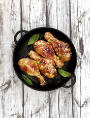 Fried chicken drumstick with sesame in a frying pan