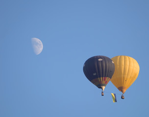 Fototapeta premium na tle księżyca latają dwa balony