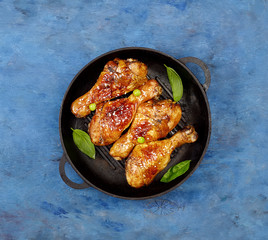 Fried chicken drumstick with sesame in a frying pan