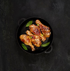 Fried chicken drumstick with sesame in a frying pan