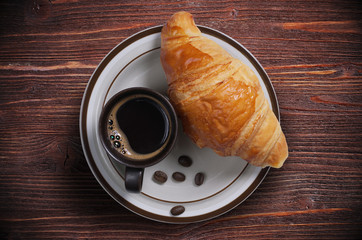 Coffee with croissant on table