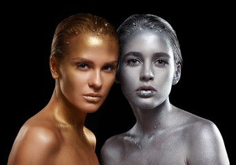 Beauty portrait of young gorgeous women. Golden and silver girls on black background