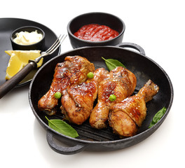 Fried chicken drumstick with sesame in a frying pan