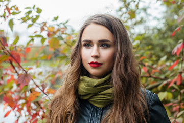 Naklejka premium Young woman walking in fall park outdoor