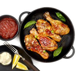 Fried chicken drumstick with sesame in a frying pan
