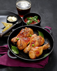 Fried chicken drumstick with sesame in a frying pan