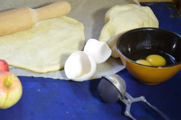 Various ingredients for winter seasonal baking and other recipes, honey, apples, herbs and spices on a dark blue background. Top view.