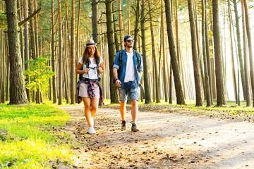 Tough route. Beautiful young couple hiking together in the woods while enjoying their journey.