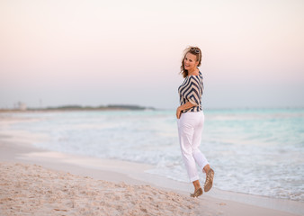 Fototapeta na wymiar modern woman on seashore at sunset walking
