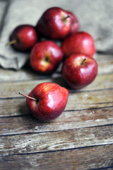 Fresh red apples on the wooden background with sack.selective focus. blurred background