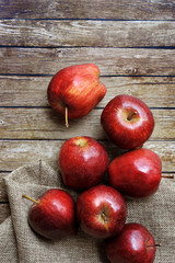 A group of fresh red apple on the wooden table with vintage sack