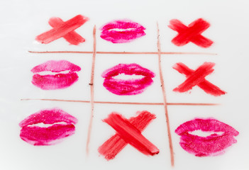 top view of tic-tac-toe with black crosses and lips prints