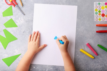 Child draws a pencil drawing empty space colorful grey background top view