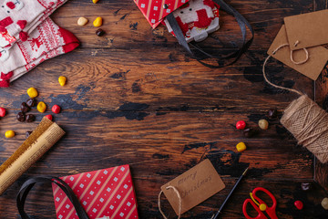 Gift boxes wrapped in red checked paper and the contents of a workspace composed. Flat lay. Valentines day, Christmas (xmas) or New year gift packing. Holiday decor concept.