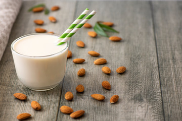 Almond milk with almond on a gray wooden table