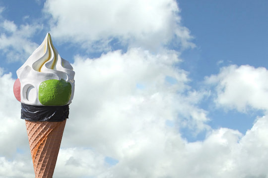 image of giant ice cream cone with sky and clouds in the background