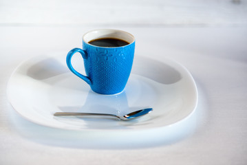 coffee in a blue cup on a light wooden background