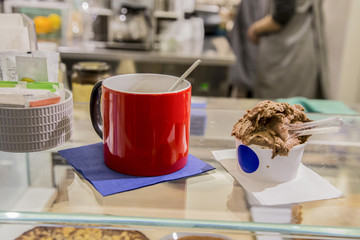 close-up image of a red cup of coffee and a chocolate flavored ice cream photographed inside a bar