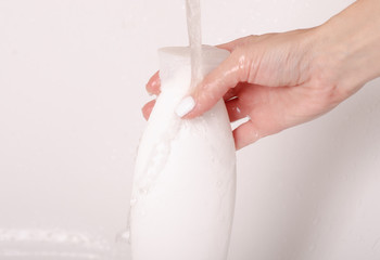 White bottle gel shower in hands water bath cosmetic care body