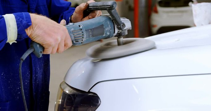 Mechanic polishing a car with grinder 4k