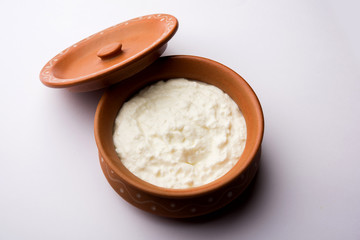 Fototapeta na wymiar Plain curd or yogurt or Dahi in Hindi, served in a bowl over moody background. Selective focus
