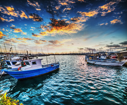 Boats in Alghero harbor at sunset