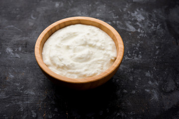 Plain curd or yogurt or Dahi in Hindi, served in a bowl over moody background. Selective focus
