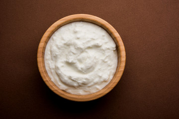 Plain curd or yogurt or Dahi in Hindi, served in a bowl over moody background. Selective focus